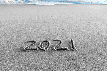 2021 year drawing on the sand at the beach.