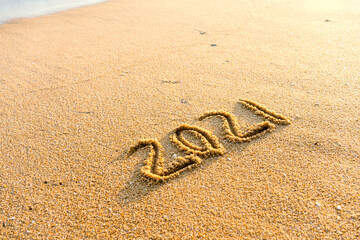 2021 year drawing on the sand at the beach.