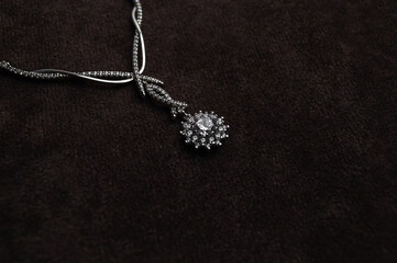 Fototapeta na wymiar Elegant silver necklace with precious stones on a black background