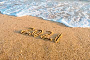2021 year drawing on the sand at the beach.