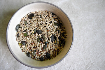 pumpkin, sunflower, sesame, Chia and flax seeds in a beige round plate top view on a light background