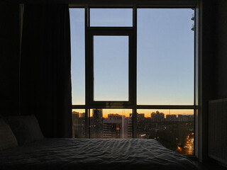 A beautiful view from the panoramic window to the sunset in the city.
