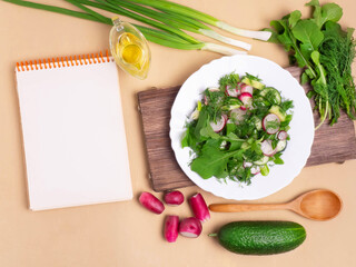 The concept of a healthy vegan diet. A clean notebook with fresh vegetables and herbs. The Concept Of Vegetarian Cooking