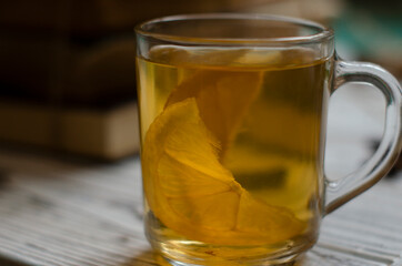 a stack of books on the table and a cup of tea with lemon
