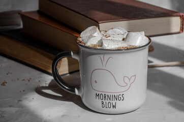 coffee with marshmallows and books on the table
