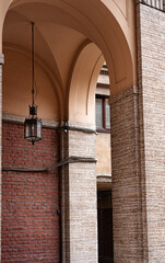 Brick stone arch with a lantern in an alley with architectural elements