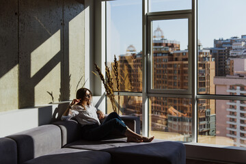 Portraits of a young woman on a sofa in the sun.