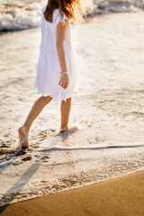 little feet leave footprints on sandy shore of sea. walks on beach. 