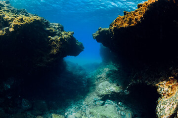 Fototapeta na wymiar Underwater view with rocks in blue ocean