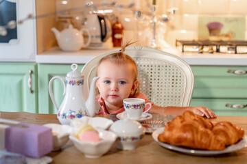 little girl made Cup of tea with cake in kitchen.festive lunch.playing with kids