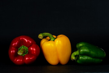 frische Paprika rot gelb grün vor schwarzem Hintergrund