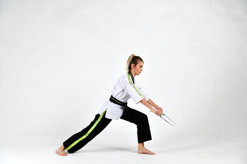 Obraz premium beautiful girl a fighter in a black and white kimono does exercises with fighting sickles