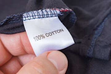 Men's hand holding clothes label 