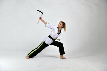 beautiful girl a fighter in a black and white kimono does exercises with fighting sickles