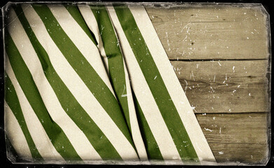 White and green striped fabric on wooden table. Top view. Vintage stile