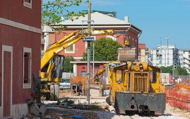 Close up bolted butt of rails and wooden sleepers laid on groundwork crushed stone. Railway wagon full of pebbles for binary support