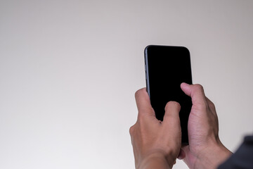 Close up Hand man holding smartphone with black screen isolated on yellow background