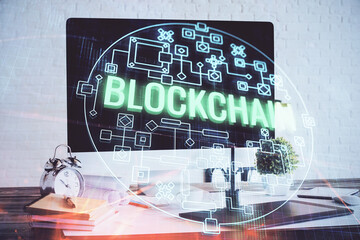 Multi exposure of blockchain and crypto economy theme hologram and table with computer background. Concept of bitcoin cryptocurrency.