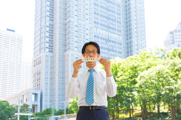 やせ型の真面目そうな日本人ビジネスマンがWELCOMEを持っている