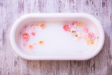 Photography decor of a antique milk bath for baby with fresh roses.