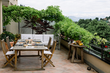 dining table with wooden chairs set on the terrace with beautiful italian landscape. food concept