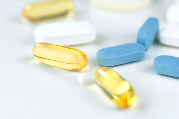 Different colorful pills on the white table background