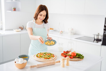 Obraz na płótnie Canvas Photo of beautiful cheerful housewife quarantine hobby preparing family recipe add finish ingredient cheese dough italian tradition pizza stay home happy modern kitchen indoors