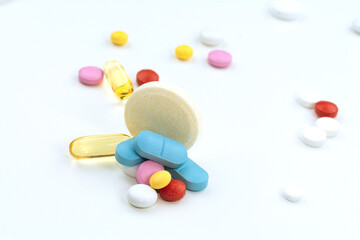 Different colorful pills on the white table background