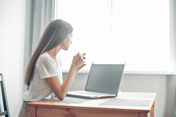 Girl working on computer laptop in light room