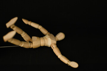 wooden mannequin with a black background sleep o the floor