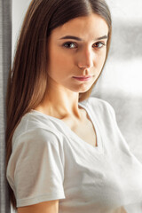 Obraz premium Beautiful young woman portrait behind window