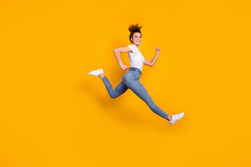 Fototapeta na wymiar Full length body size view of her she nice attractive lovely sporty cheerful cheery girl jumping running marathon distance isolated on bright vivid shine vibrant yellow color background