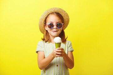 Beautiful little girl holding an ice cream and going to eat it, licking her lips, dressed in a...