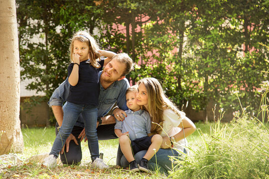 Bellissima famiglia composta da 2 genitori e figli si raduna felice in gruppo nel giardino di casa