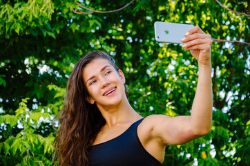Woman makes a selfie in park
