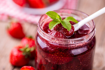 Homemade delicious strawberry jam and strawberry on a rustic wooden table