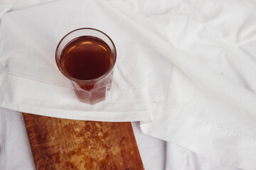 glass with tea on a white vintage background and table