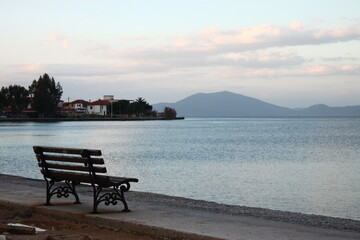 Naklejka na ściany i meble An empty bench in front of the sea 