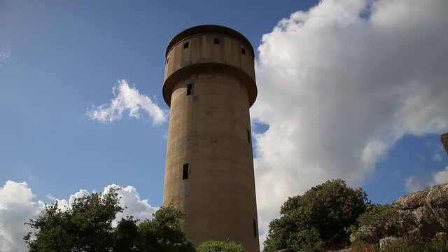 Luras - Italy, June 2020. Tower water tank, timelapse clouds and blue sky