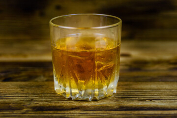 Glass of whiskey on the dark wooden background