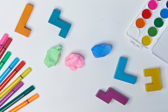 felt-tip pens, cubes, paints and plasticine on a white background. children's desktop. School, education and learning concept. creativity for kids. Top view colorful background. Flat lay
