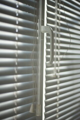 Closed horizontal blinds with rope and handle. Perspective view,
