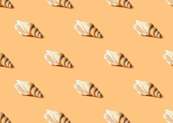 Seamless colorful pattern of shells on pastel orange color background. From top view. Conceptual trendy style. Minimal background