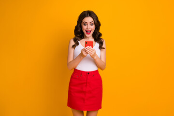 Photo of funky millennial lady open mouth hold telephone read positive blog post comments wear casual white tank-top red short skirt isolated bright yellow color background