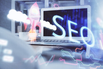 Multi exposure of table with computer and seo drawing hologram. Search optimization concept.