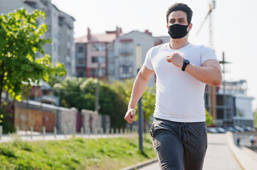 Portrait sports arabian man in black medical face mask run outdoor during coronavirus quarantine.
