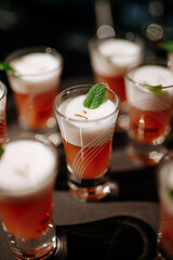 Close up of shot-drinks set with white foam and mint leaf