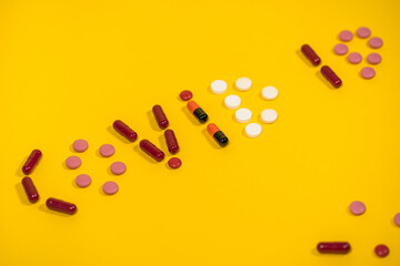 Closeup view photography of word Covid 19 made on bright orange background by different colorful pills.