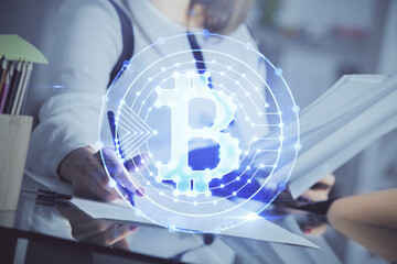 Cryptocurrency hologram over woman's hands writing background. Concept of blockchain. Double exposure