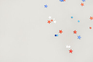 Festive background with confetti in the shape of stars in the color of the American flag. US...